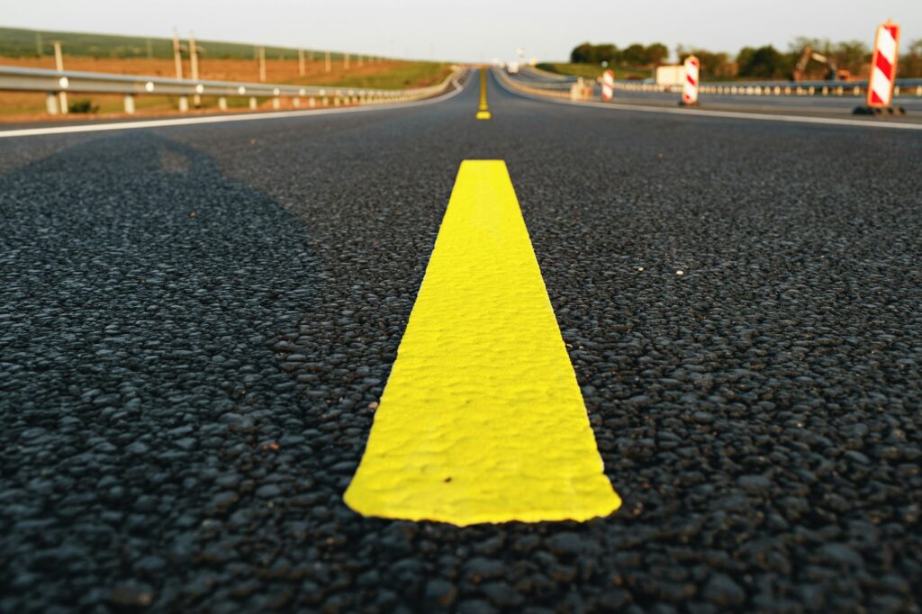 Yellow road markings on asphalt road close up